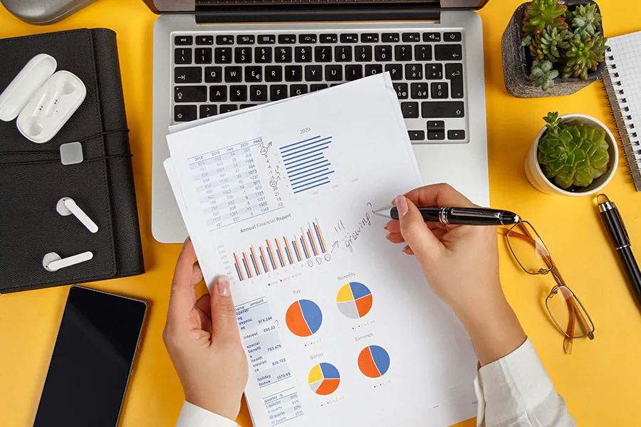 Businesswoman making notes on a business report at her desk